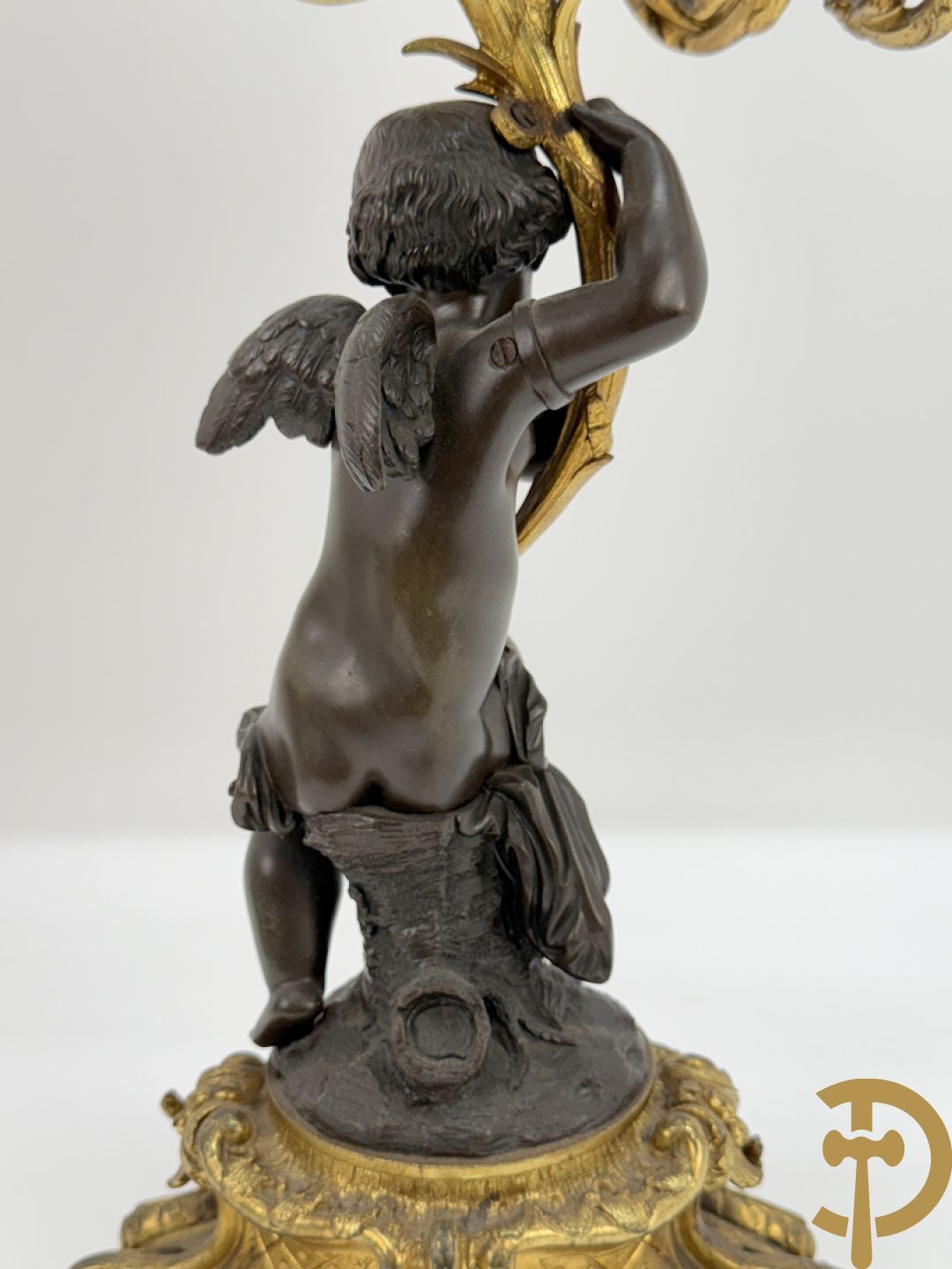 Bronzen cupido dragende een zevenarmige kandelaar