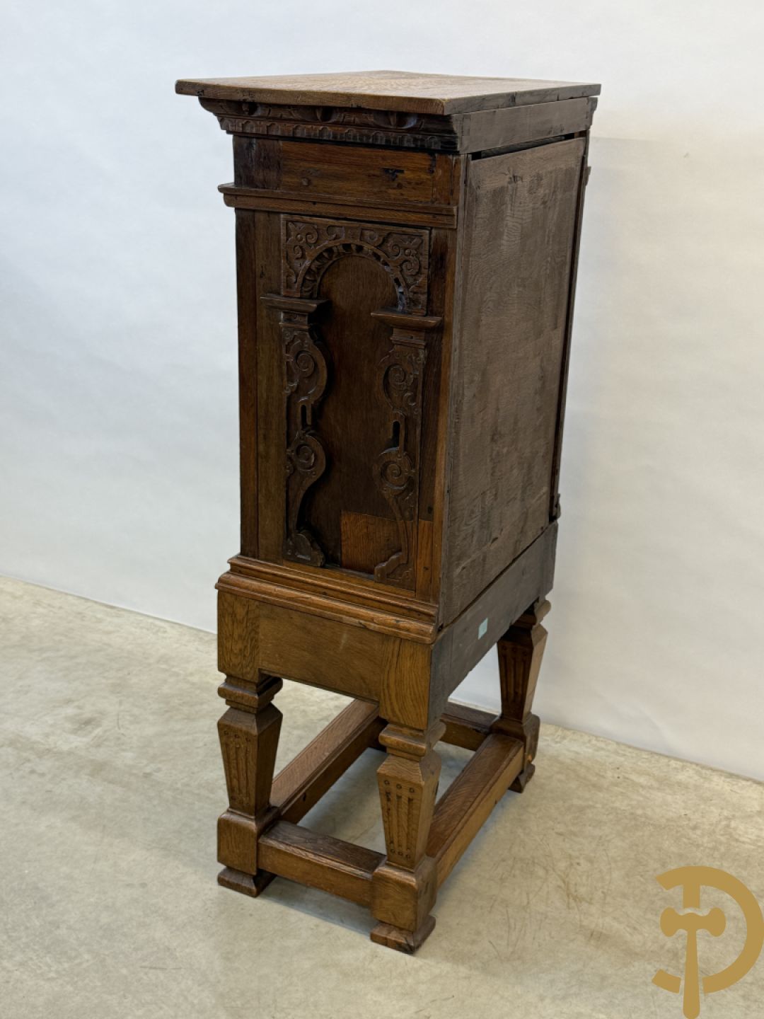 Massief eiken ééndeurskast op onderstel met lade bovenaan, lade onderaan, sculptuur in zijkant en deur