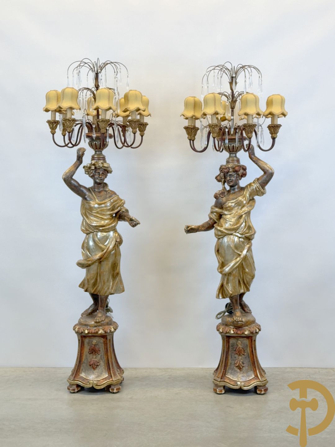 Paar gepolychromeerde dames op sokkel, bekroond met achtarmige kandelaar met lichtpunten en bellen, Italiaans, jaren 