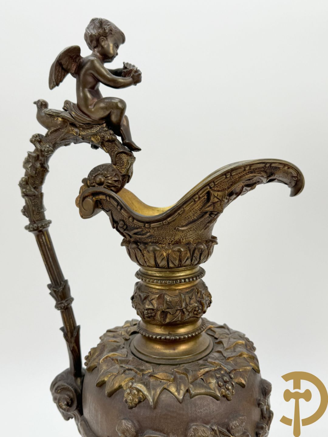 Paar bronzen schenkkannen met basrelief van putti en accanthusranken