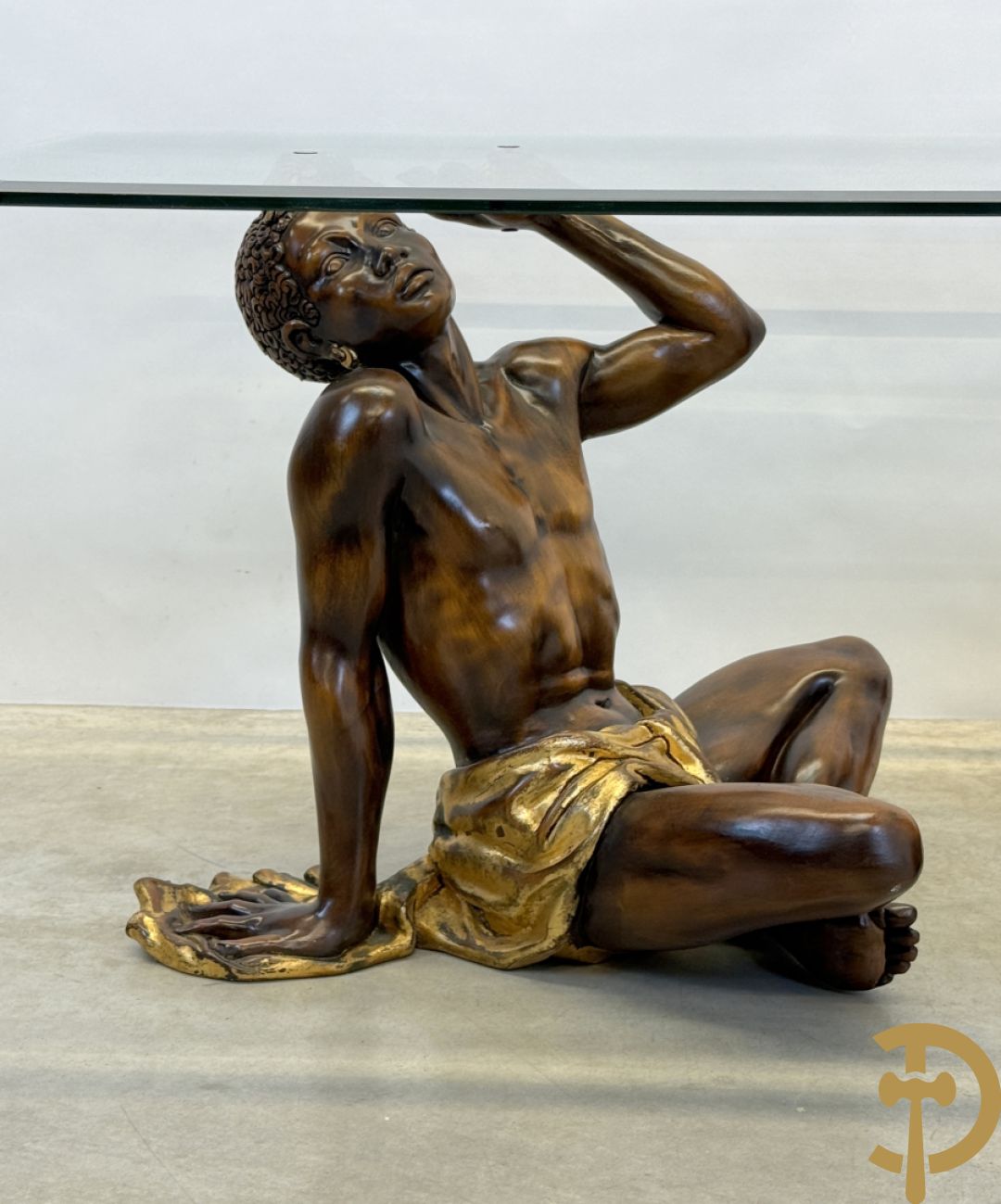 Salontafel met een paar moren met vergulde lendendoek dragende een achthoekig geslepen glazen blad