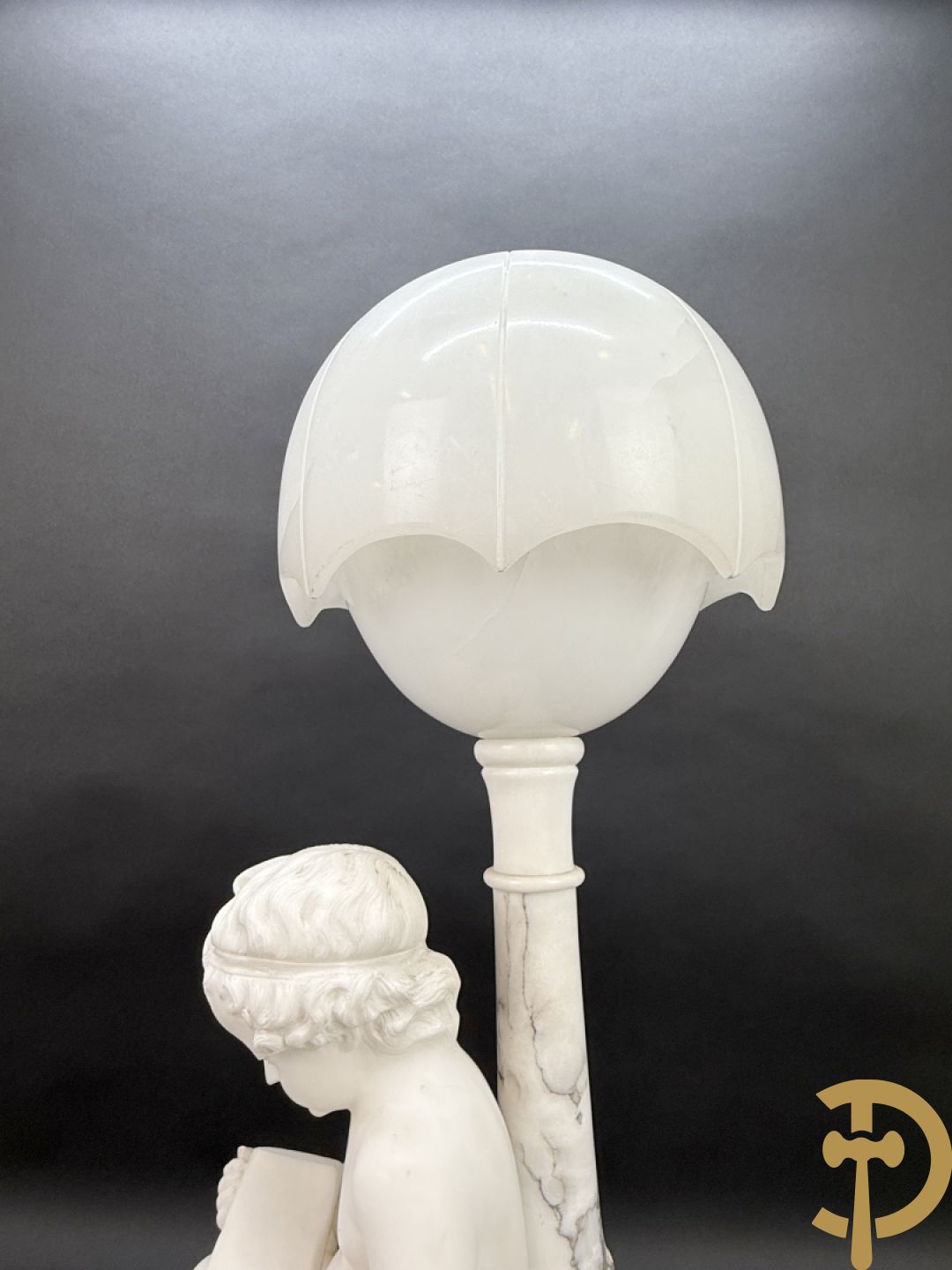 Albast beeld van jongen met boek en lamp