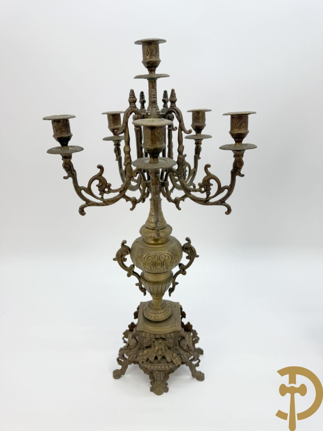 Driedelige koperen garnituur, klok geflankeerd door paar vijfarmige kandelaars