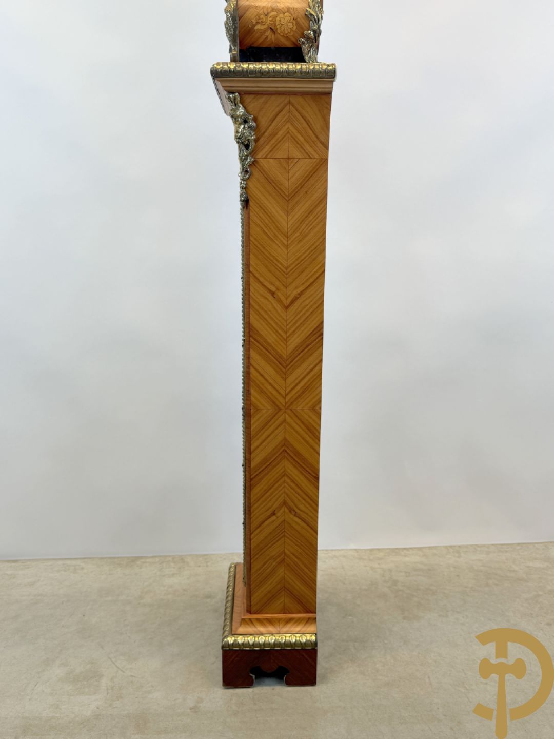 Notelaren pendule met bloemenmarquetterie en bronsbeslag, bovenaan bekroond met bronzen figuur - met bijhorende sokkel in notelaar met bronsbeslag