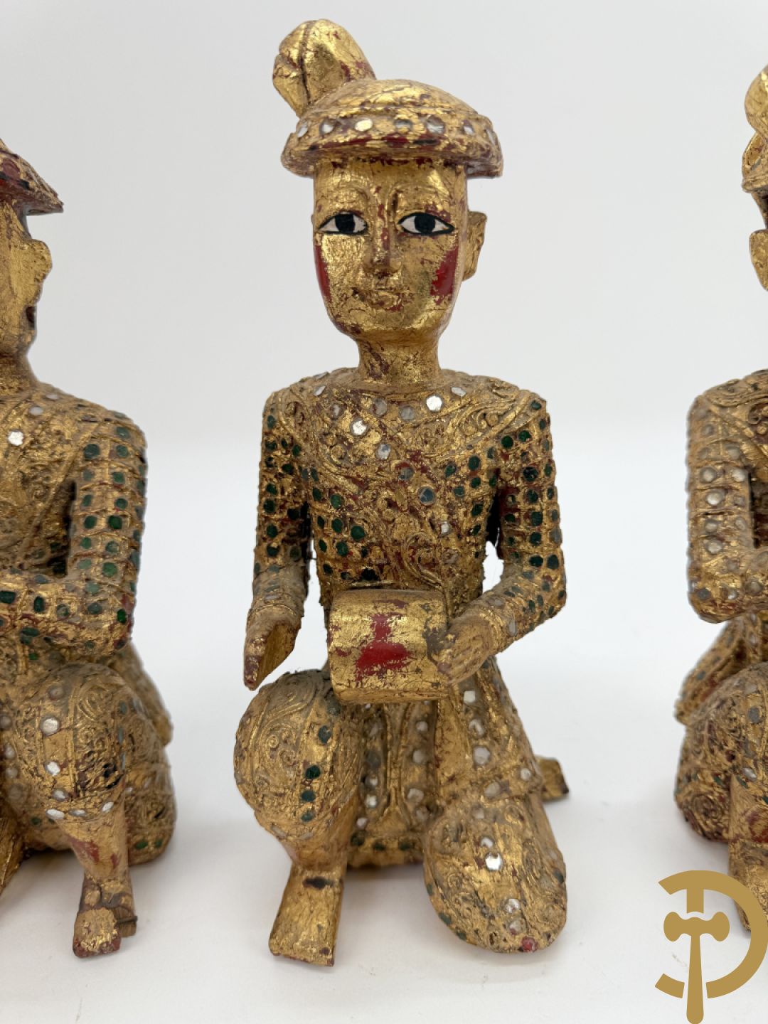 Negen houtgesculpteerde boedhistische figuren waarvan enkele verguld