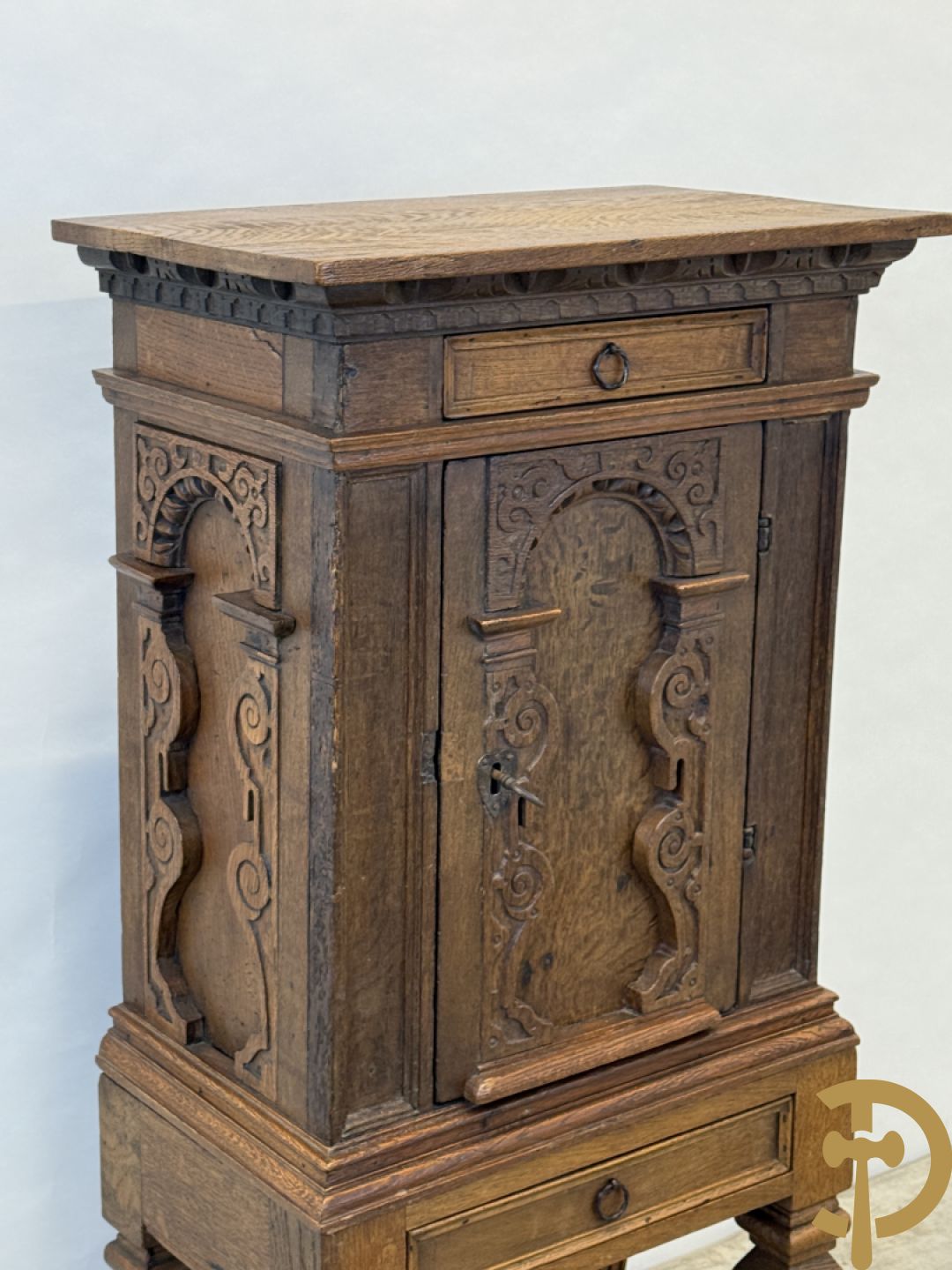 Massief eiken ééndeurskast op onderstel met lade bovenaan, lade onderaan, sculptuur in zijkant en deur