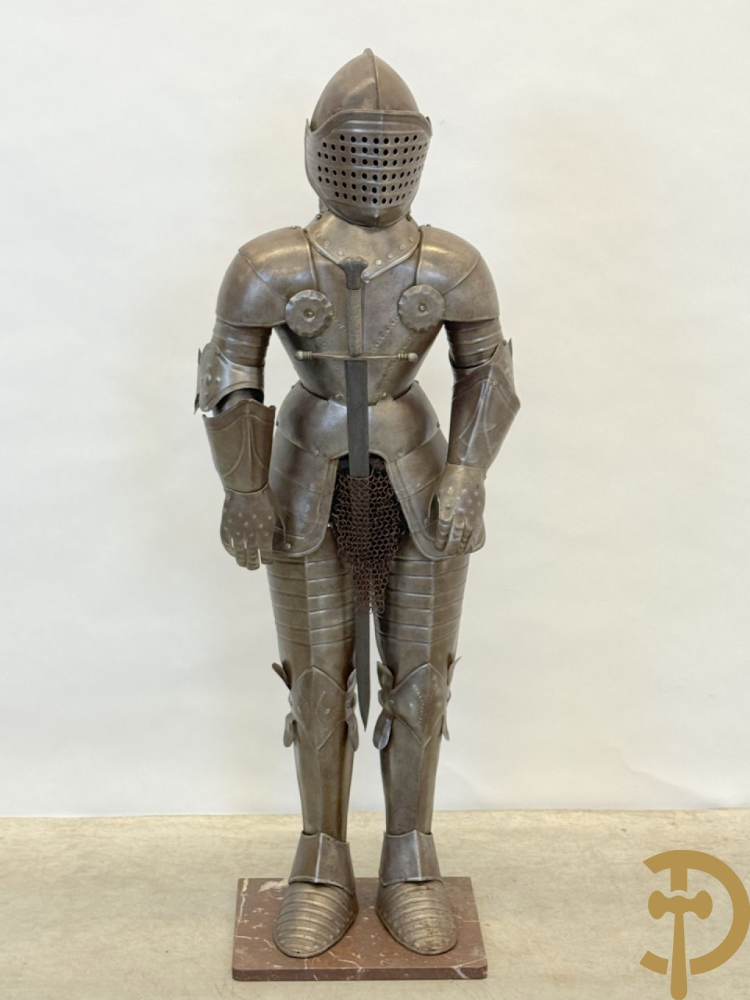 Decoratief plaatstalen ridderharnas met zwaard op marmeren voet