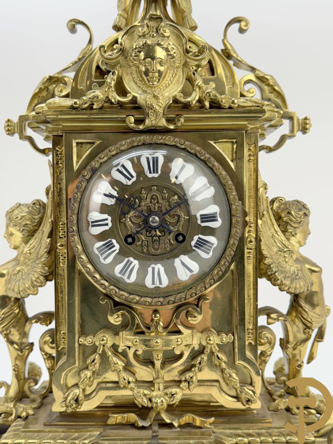 Driedelige bronzen vergulde garntiuur bestaande uit klok met medusahoofden en sfinxen, geflankeerd door paar zevenarmige kandelaars met accanthusranken en sfinxen