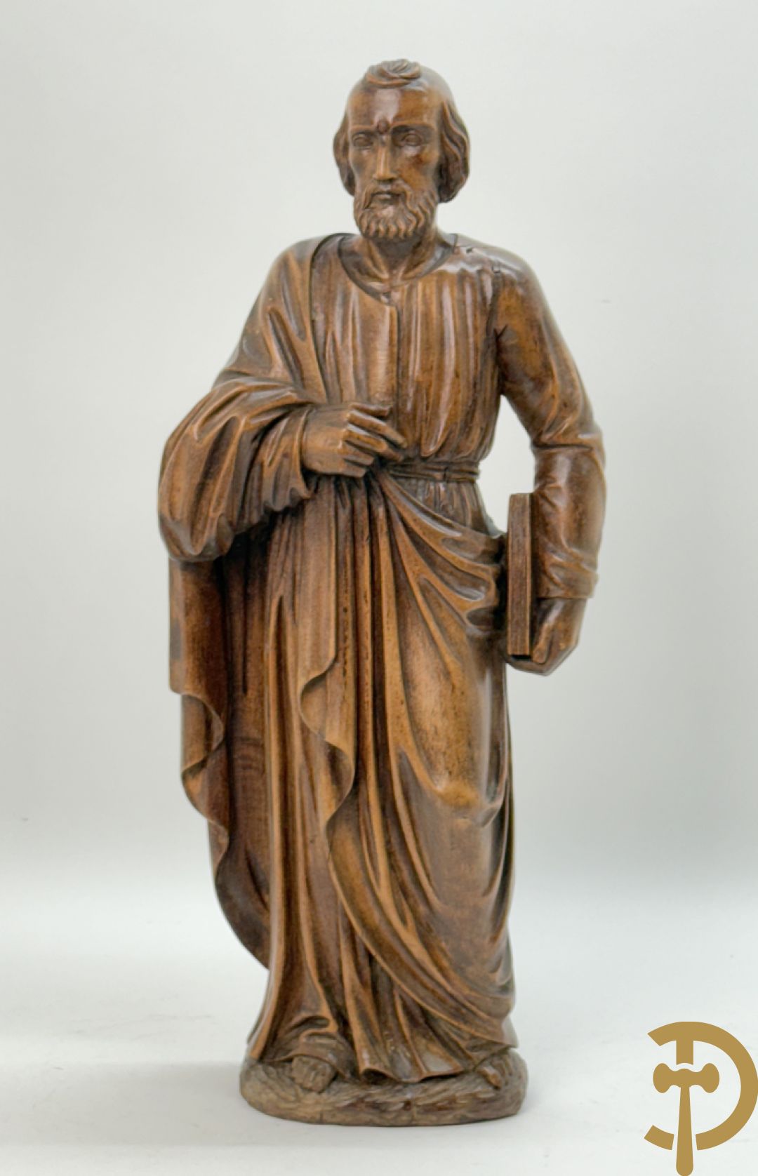 Houtsculptuur van evangelist met boek in de hand