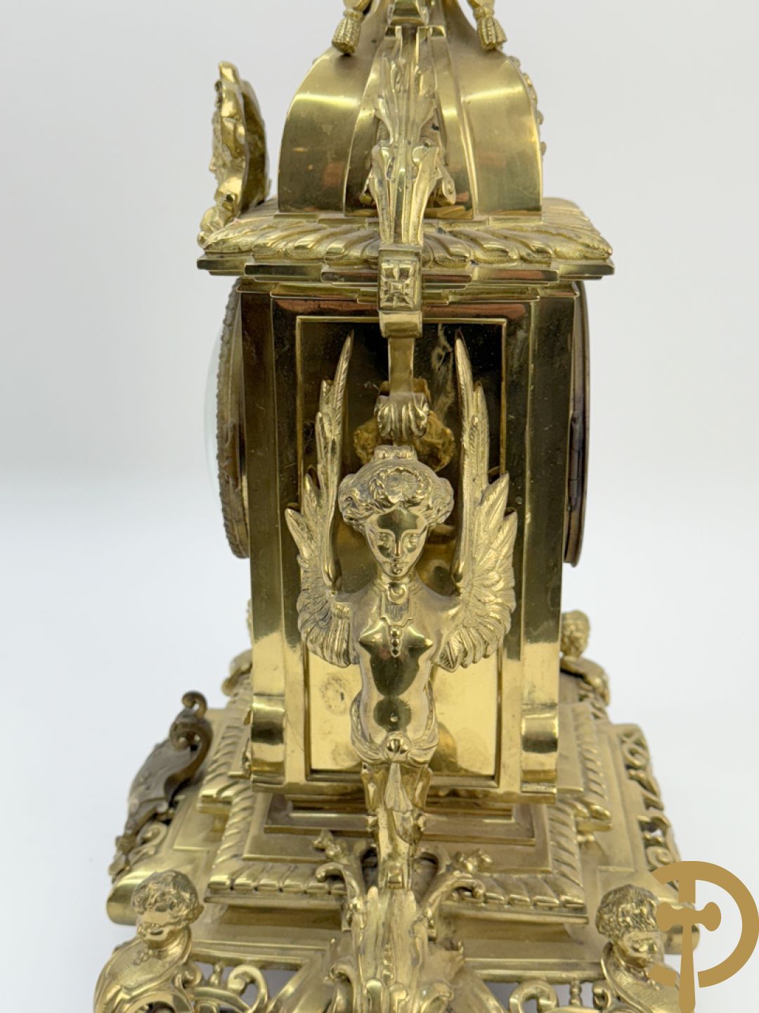 Driedelige bronzen vergulde garntiuur bestaande uit klok met medusahoofden en sfinxen, geflankeerd door paar zevenarmige kandelaars met accanthusranken en sfinxen