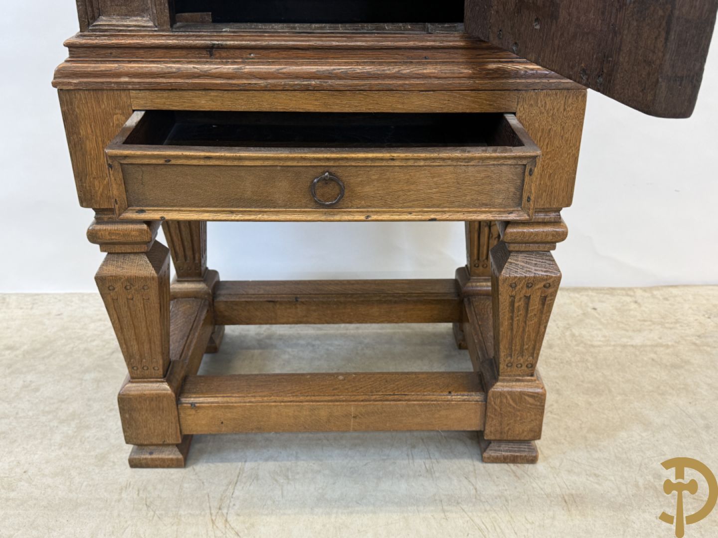 Massief eiken ééndeurskast op onderstel met lade bovenaan, lade onderaan, sculptuur in zijkant en deur