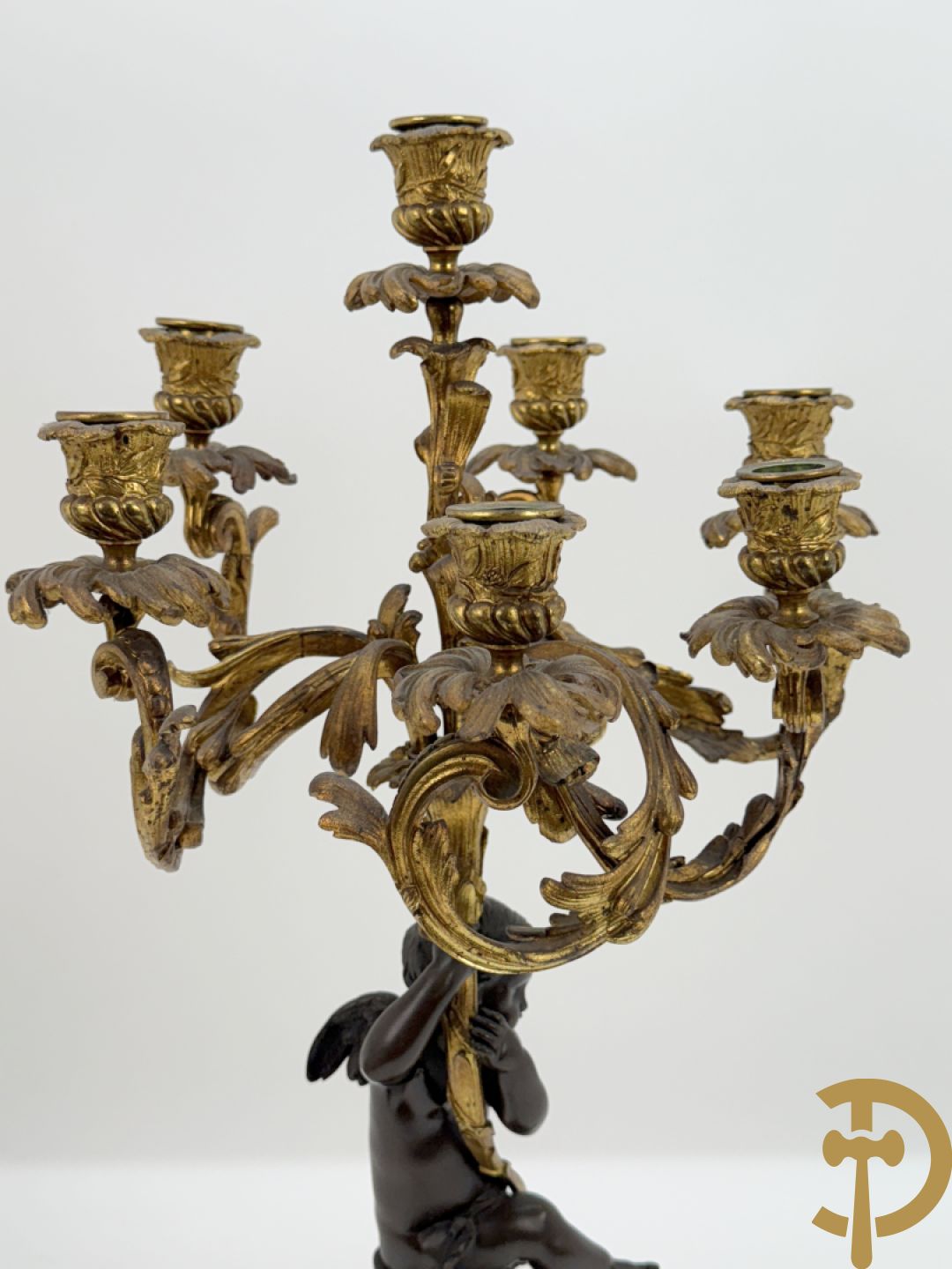 Bronzen cupido dragende een zevenarmige kandelaar