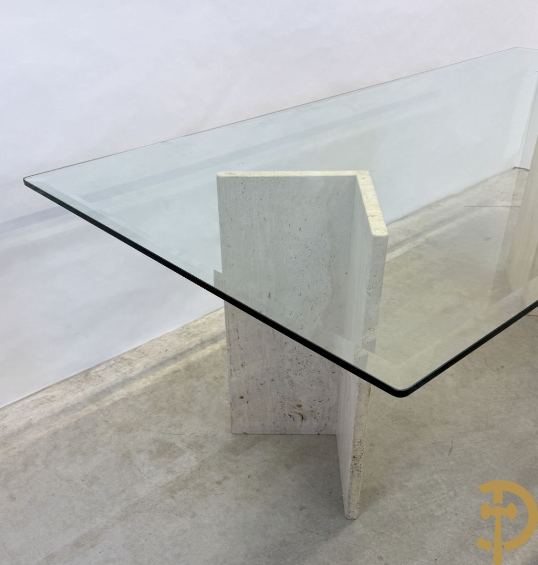 Moderne tafel met geslepen glazen blad op 2 travertin steunen