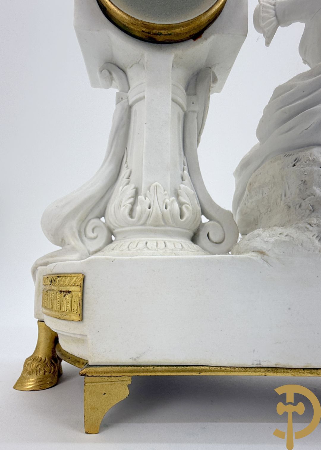 Driedelige porseleinen garnituur met bronsbeslag bestaande uit pendule met dame en amfoor geflankeerd door paar kandelaars bezet met personages