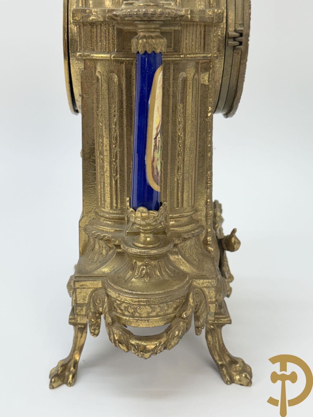 Driedelige koperen garnituur bestaande uit pendule met beschilderd romantisch tafereel en amfoor, zijdelings bezet met paar cassolettes met geanimeerde scènes, onleesbaar getekend rechts onder klok