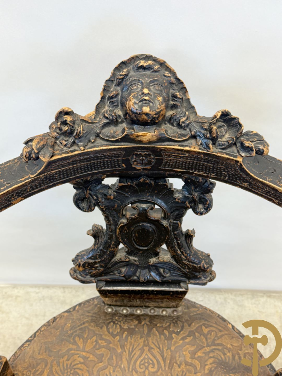 Gesculpteerde draaibare gondelvormige stoel steunend op 4 poten in de vorm van dolfijnen, bovenaan met kariathiden en engelenkoppen