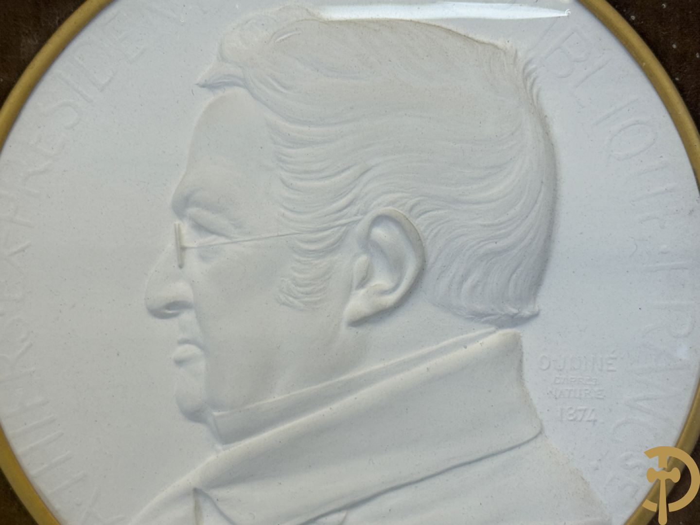 Kader met twee porseleinen plakkettes en 3 munten van Oudiné Eugène André