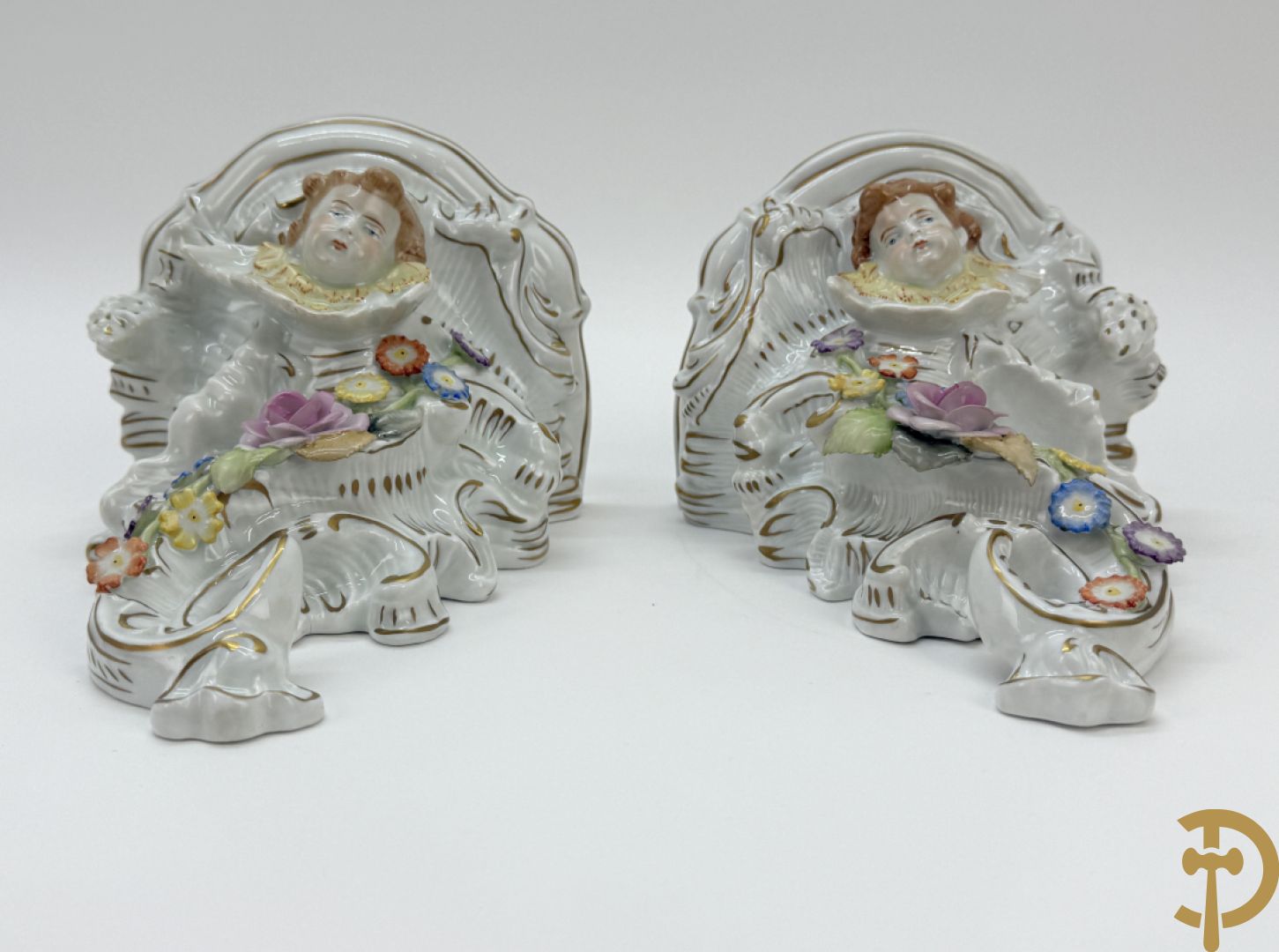 Paar porseleienen consooltjes met cupido