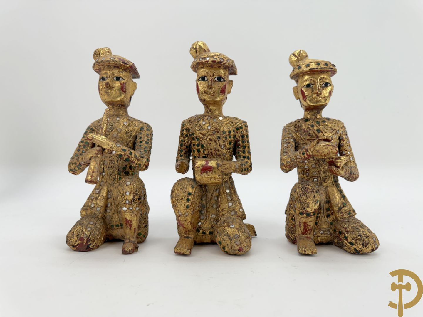 Tien houtgesculpteerde boedhistische figuren waarvan enkele verguld