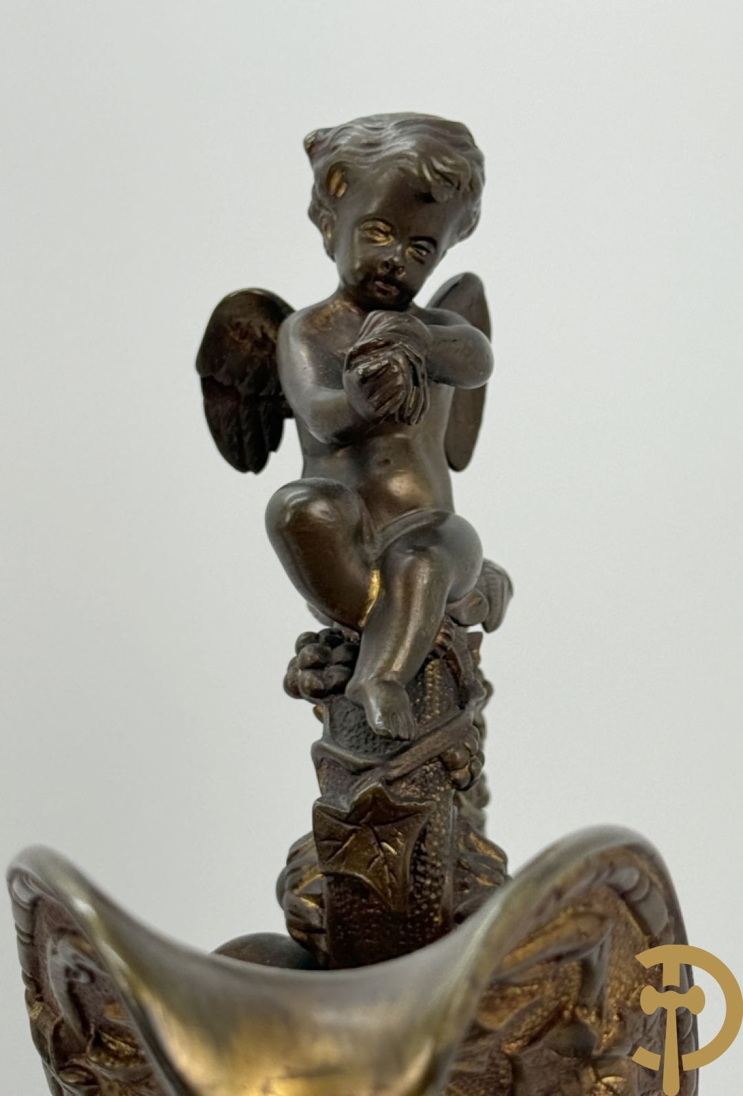 Paar bronzen schenkkannen met basrelief van putti en accanthusranken