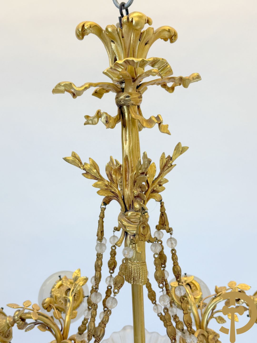 Bronzen vuurvergulde luchter met 4 paar lichtpunten bezet met bladranken, onderaan met glazen schelpen en armen bezet met cupidohoofden