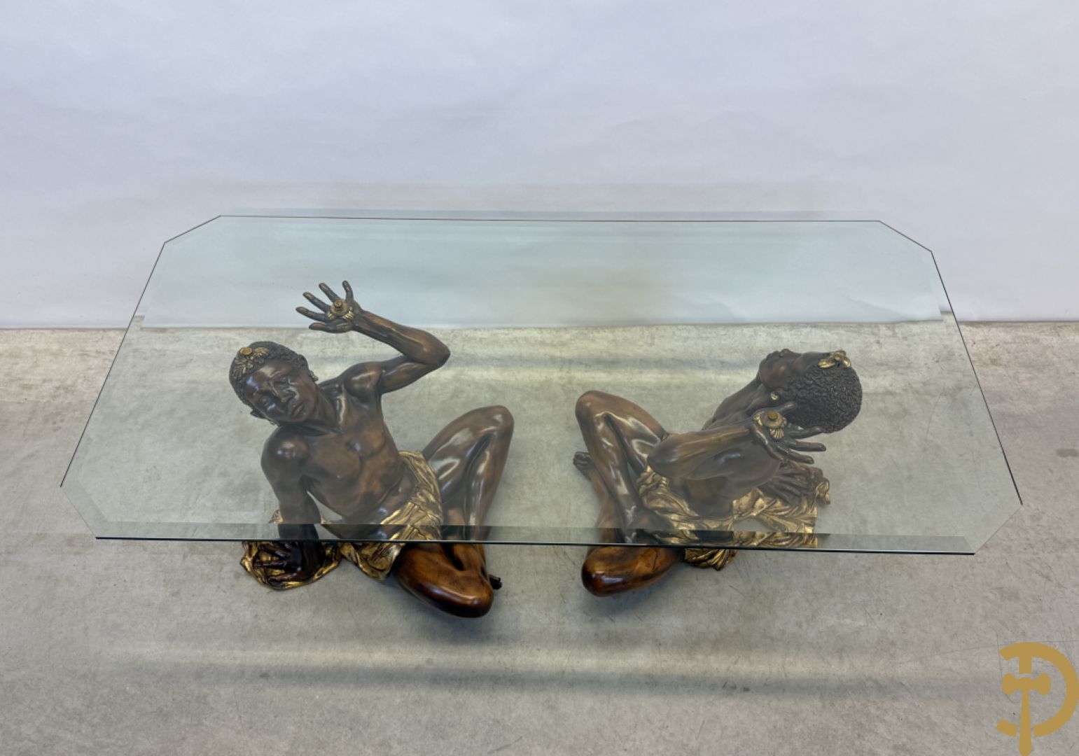 Salontafel met een paar moren met vergulde lendendoek dragende een achthoekig geslepen glazen blad