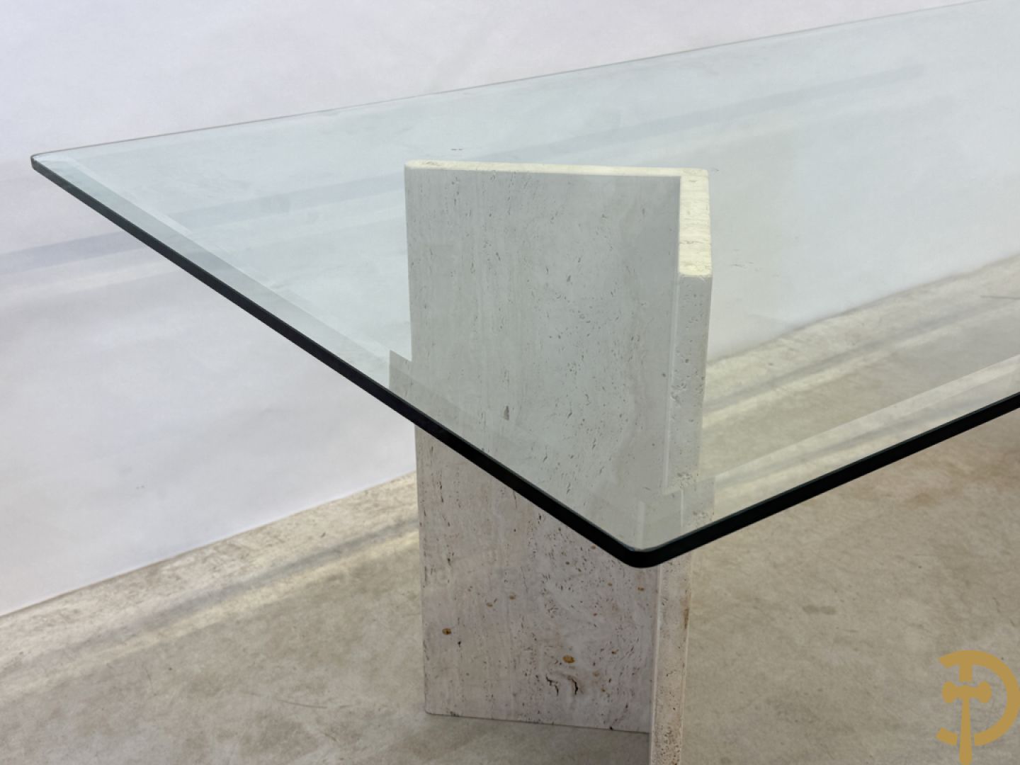 Moderne tafel met geslepen glazen blad op 2 travertin steunen