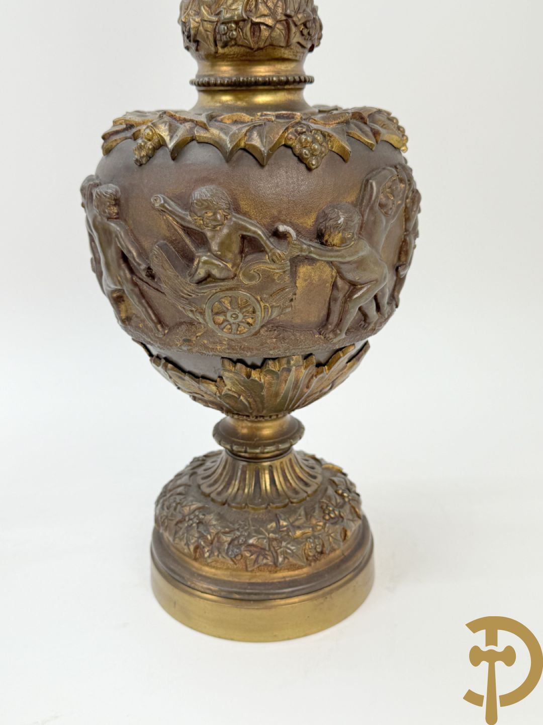 Paar bronzen schenkkannen met basrelief van putti en accanthusranken