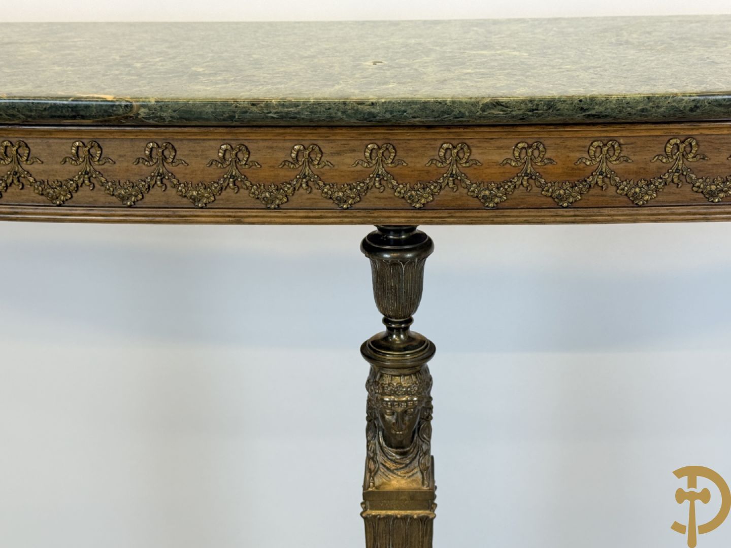 Console op bronzen poten met dameshoofden bezet, bovenaan met groen marmeren blad