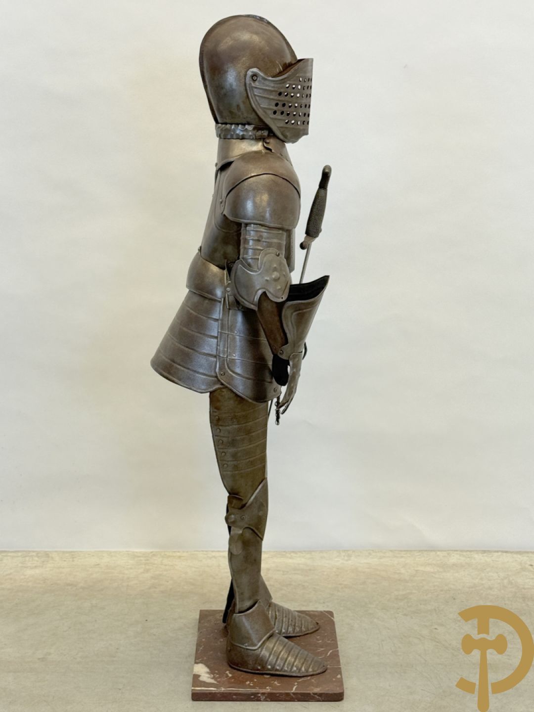 Decoratief plaatstalen ridderharnas met zwaard op marmeren voet