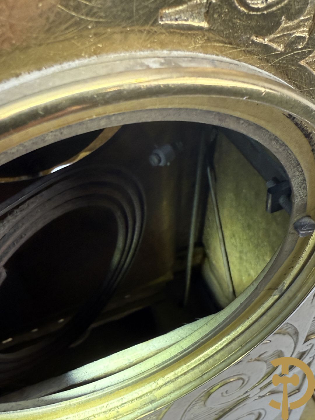 Vuurvergulde bronzen pendule, zijdelings bezet met gevleugelde dames, bovenaan met amfoor