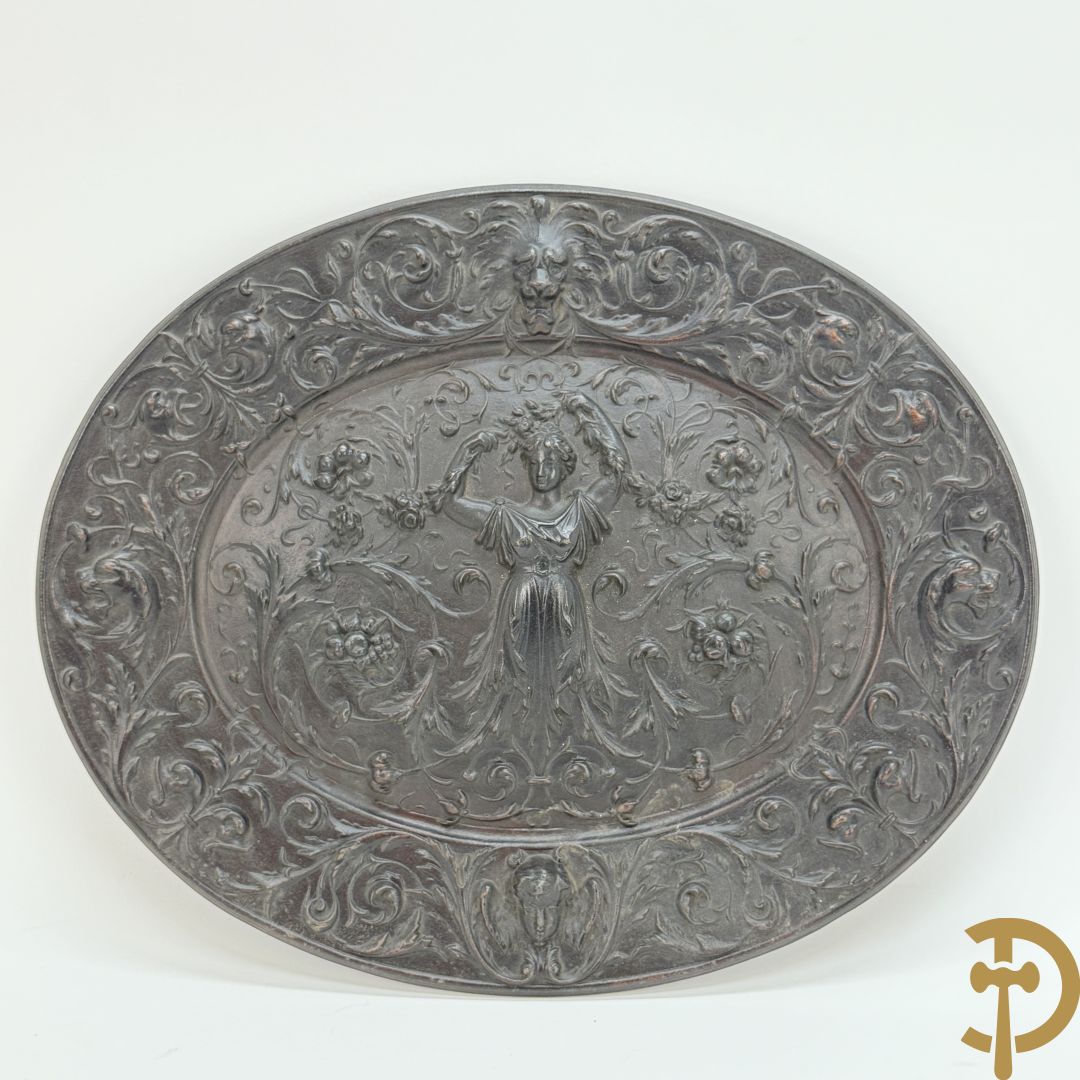 Metalen ovale schotel met dame omgeven door bloemen en accanthusranken, achteraan getekend American Radiator Cie