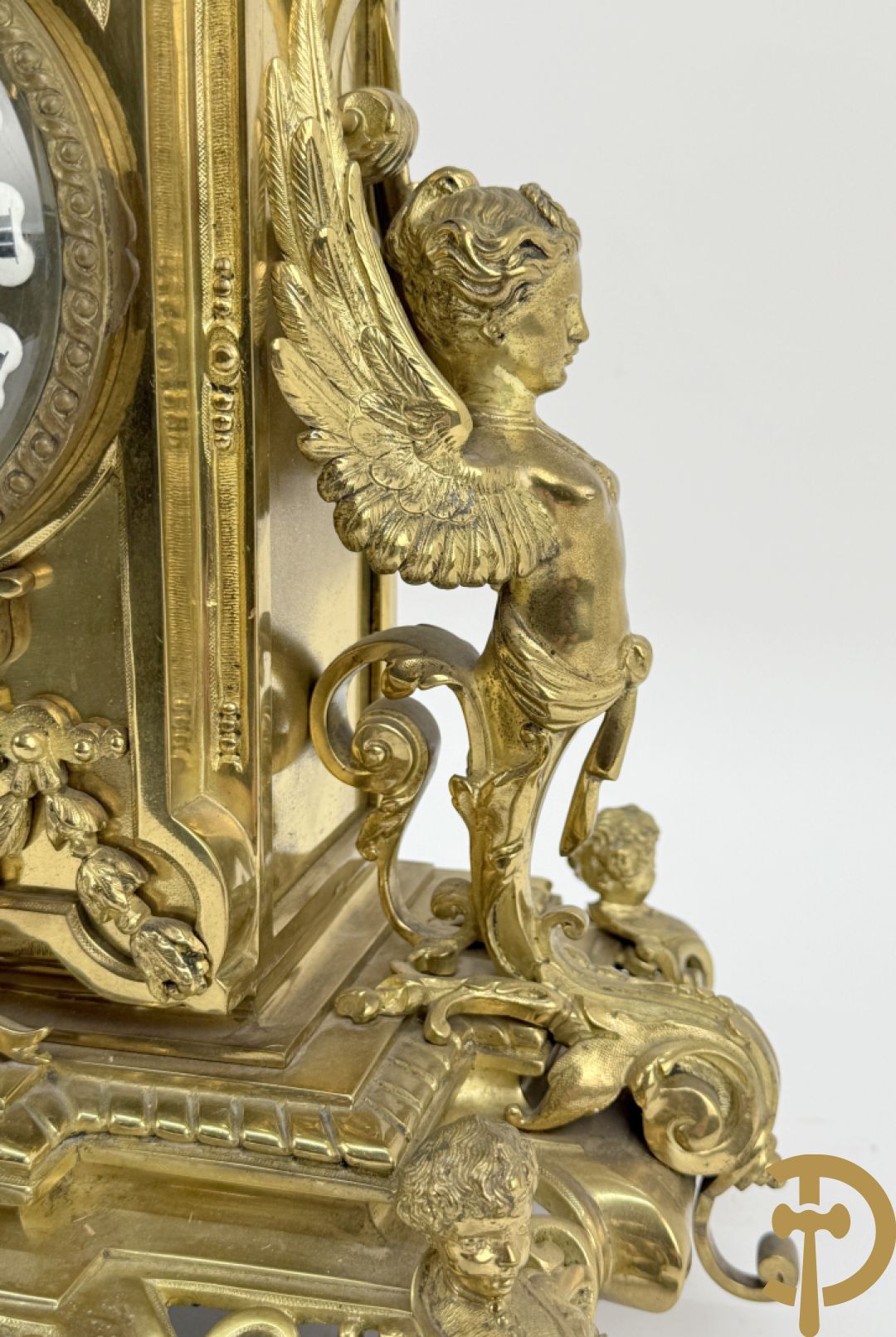 Driedelige bronzen vergulde garntiuur bestaande uit klok met medusahoofden en sfinxen, geflankeerd door paar zevenarmige kandelaars met accanthusranken en sfinxen