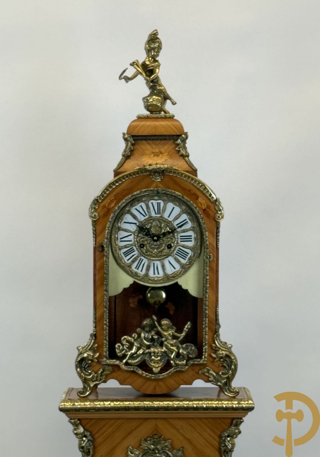 Notelaren pendule met bloemenmarquetterie en bronsbeslag, bovenaan bekroond met bronzen figuur - met bijhorende sokkel in notelaar met bronsbeslag