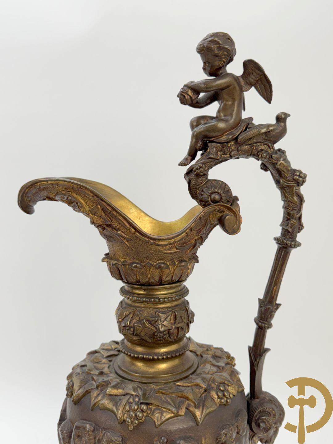 Paar bronzen schenkkannen met basrelief van putti en accanthusranken