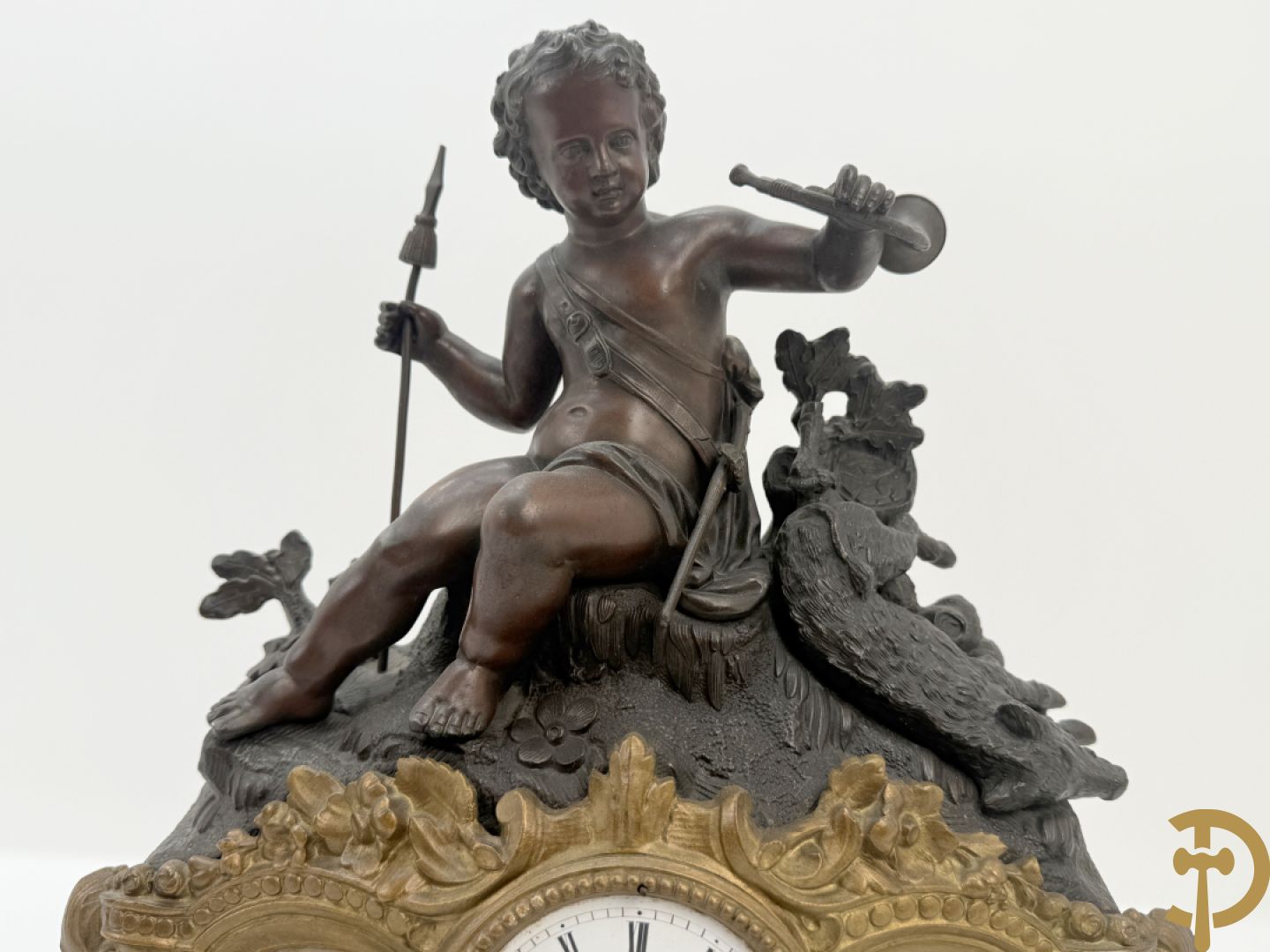 Zamak pendule met accanthusranken en bekroond met cupido met jachthoorn