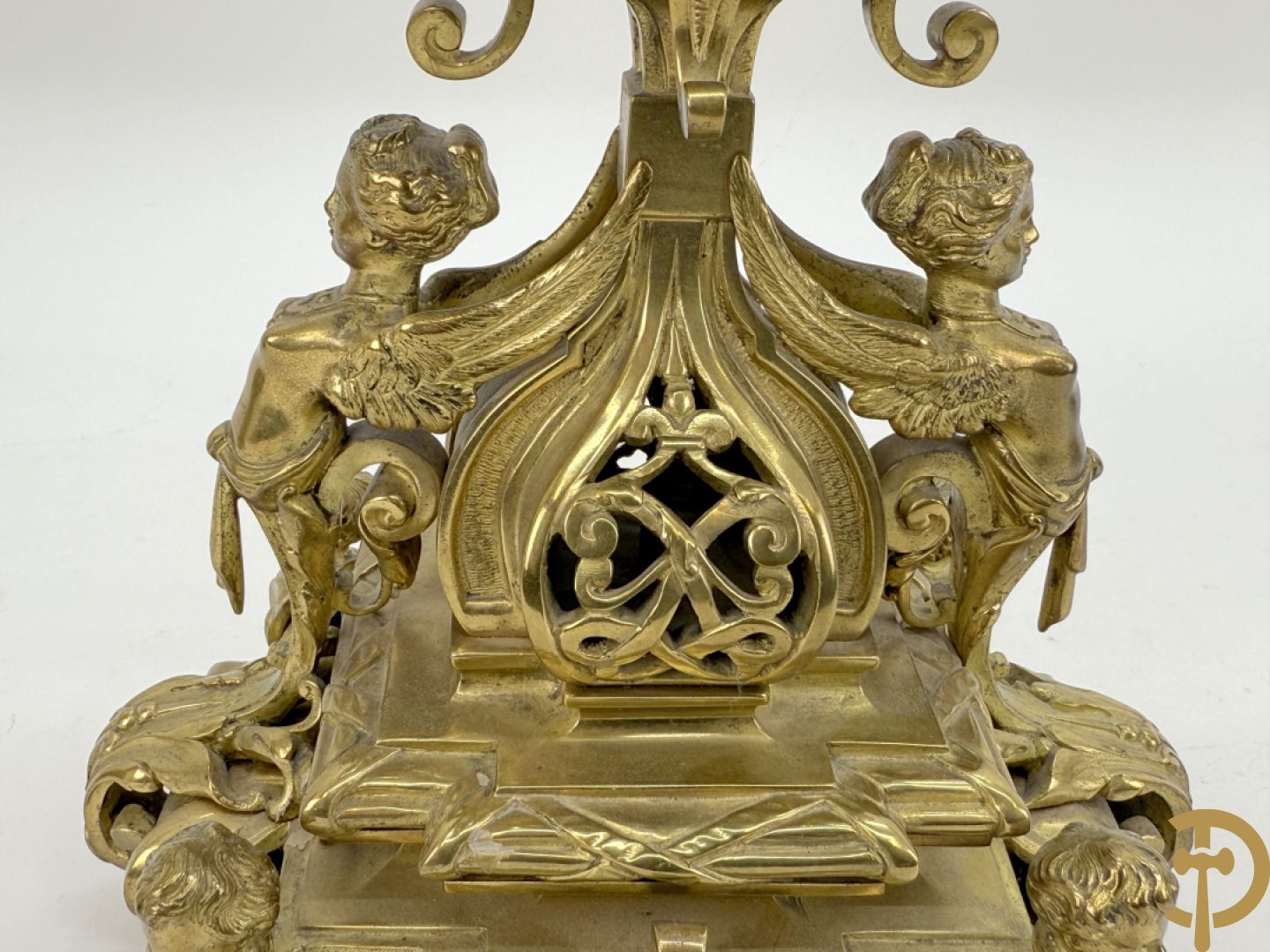 Driedelige bronzen vergulde garntiuur bestaande uit klok met medusahoofden en sfinxen, geflankeerd door paar zevenarmige kandelaars met accanthusranken en sfinxen
