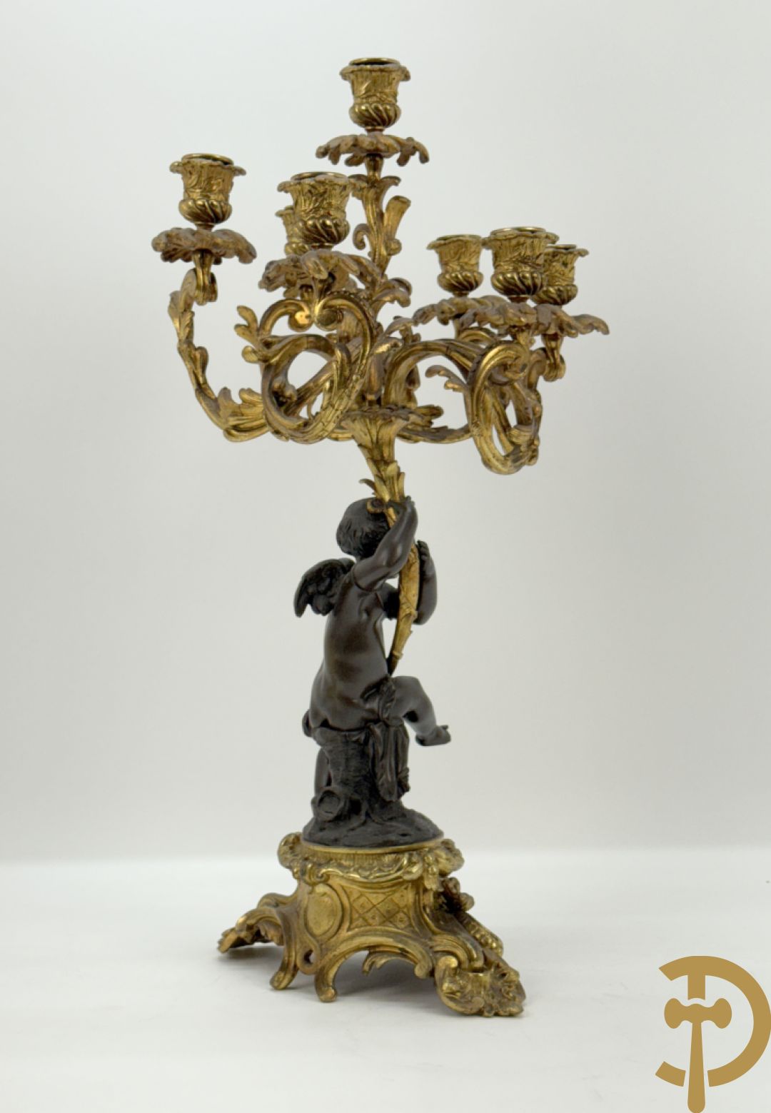 Bronzen cupido dragende een zevenarmige kandelaar