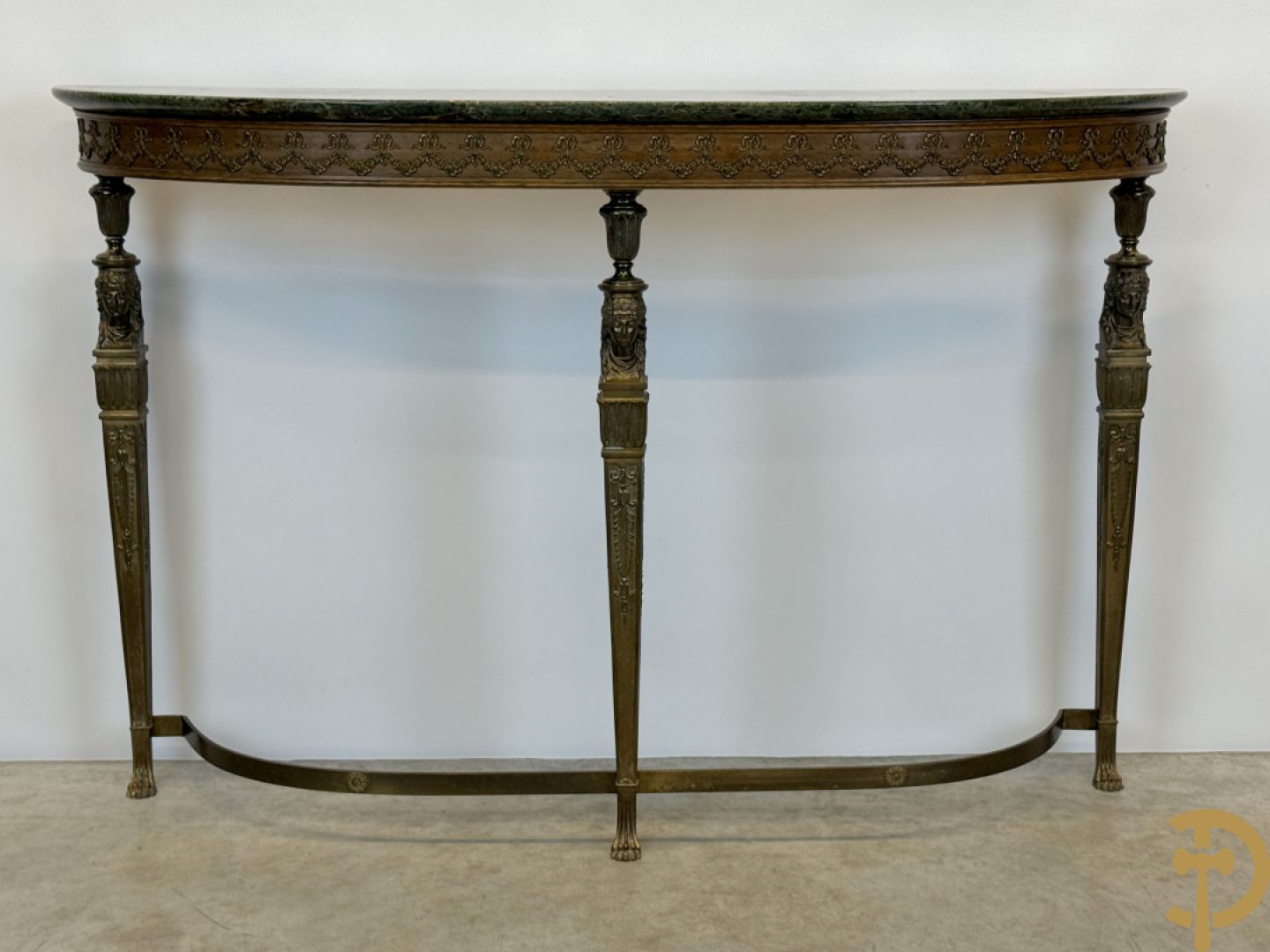 Console op bronzen poten met dameshoofden bezet, bovenaan met groen marmeren blad