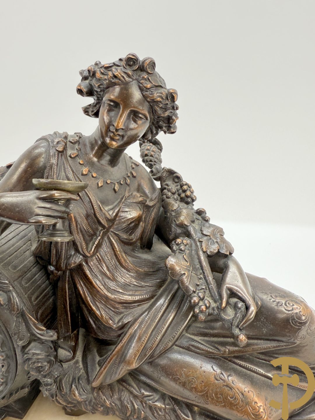 Kunstbronzen pendule liggende dame met beker op marmeren sokkel
