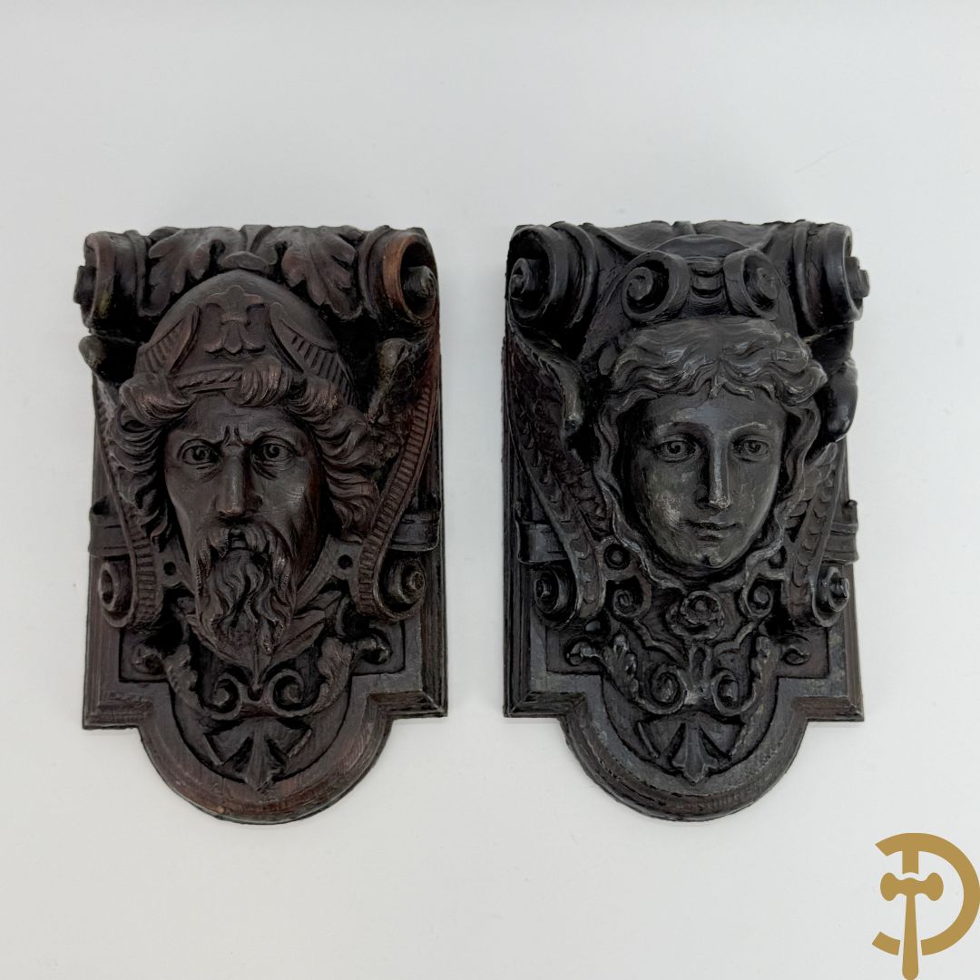 Paar muurhoeksteunen van hout met gesculpteerde hoofden man en vrouw