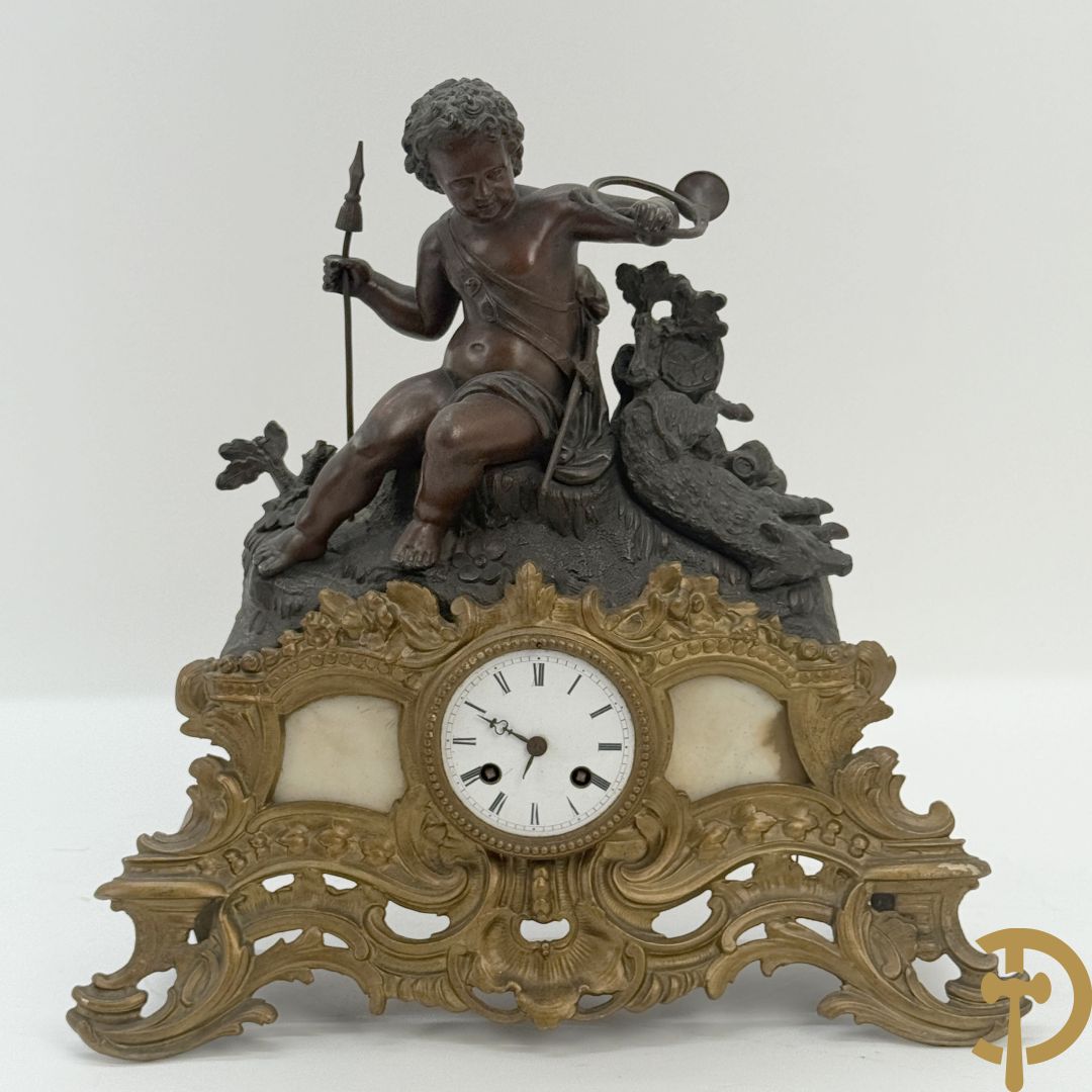 Zamak pendule met accanthusranken en bekroond met cupido met jachthoorn