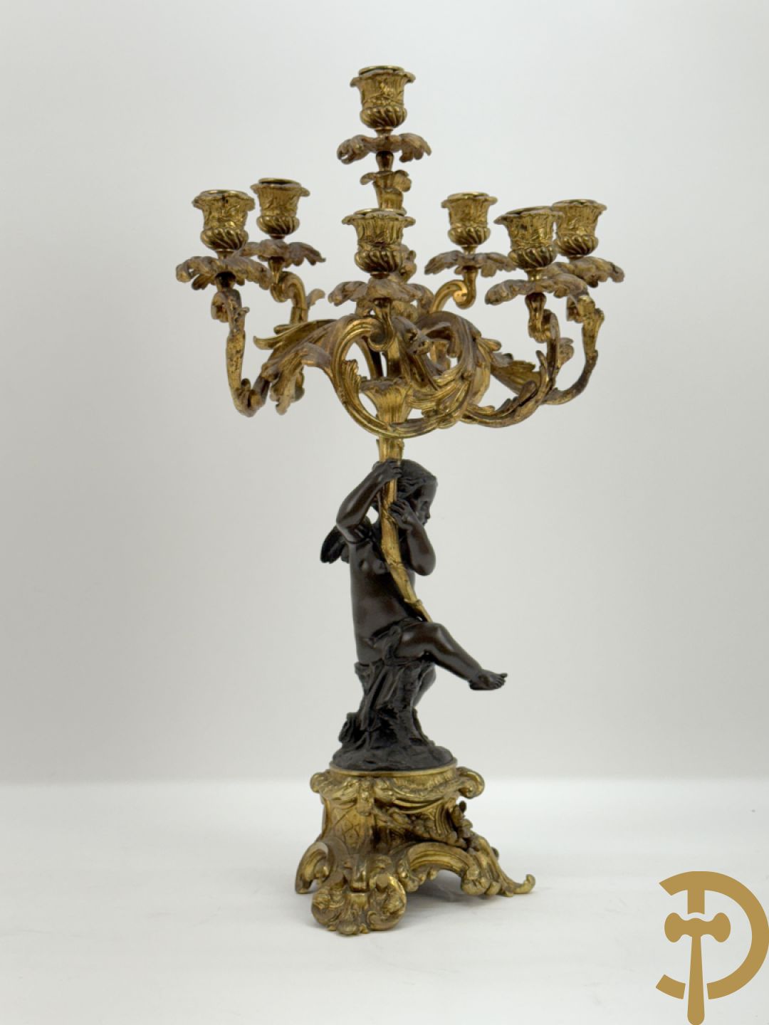 Bronzen cupido dragende een zevenarmige kandelaar