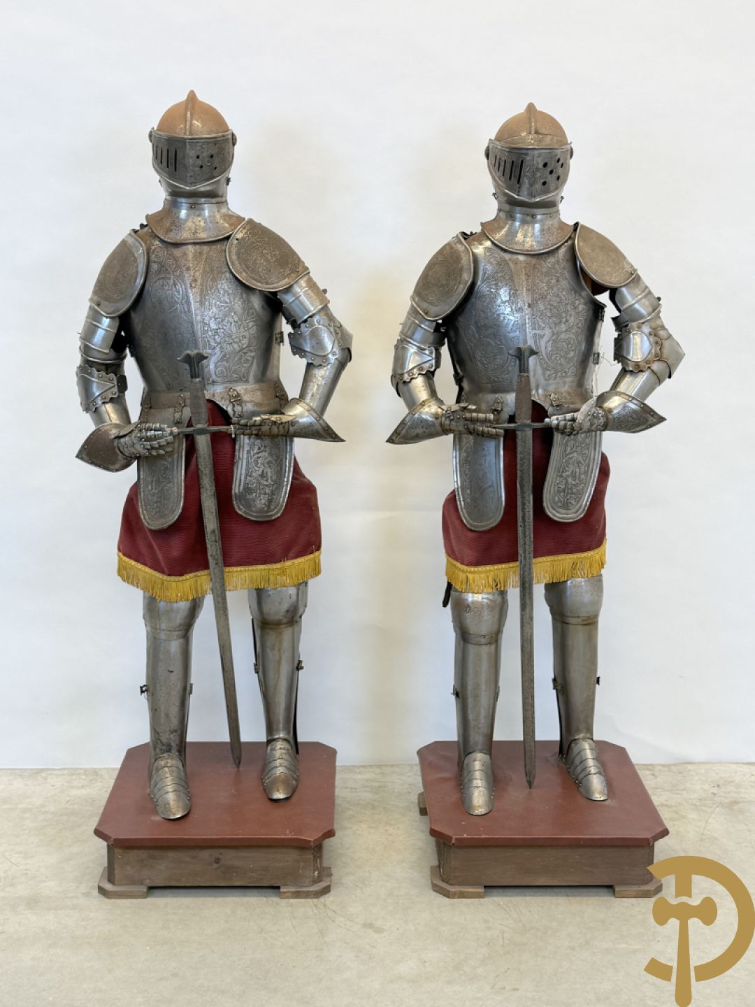 Paar ijzeren decoratieve harnassen ridderuitrusting met geciseleerde motieven op de elementen, met zwaard en ridderhelm - op statief - vermoedelijk Spaans 1930-1940