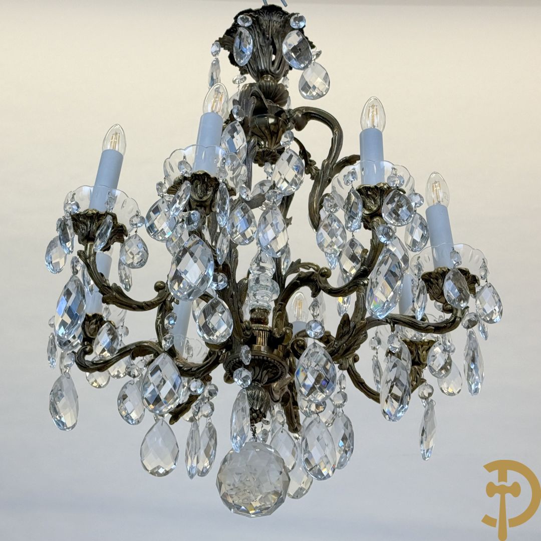 Achtarmige koperen luchter met kristallen bellen en binnenin met pinakel bezet