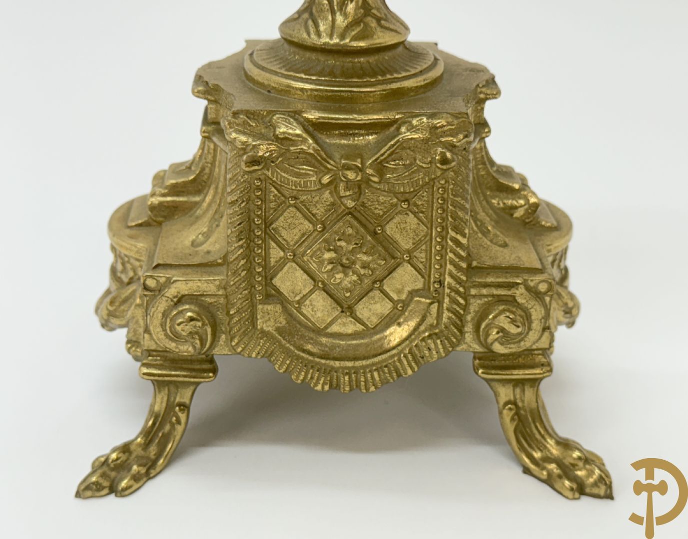 Driedelige koperen garnituur bestaande uit pendule met beschilderd romantisch tafereel en amfoor, zijdelings bezet met paar cassolettes met geanimeerde scènes, onleesbaar getekend rechts onder klok