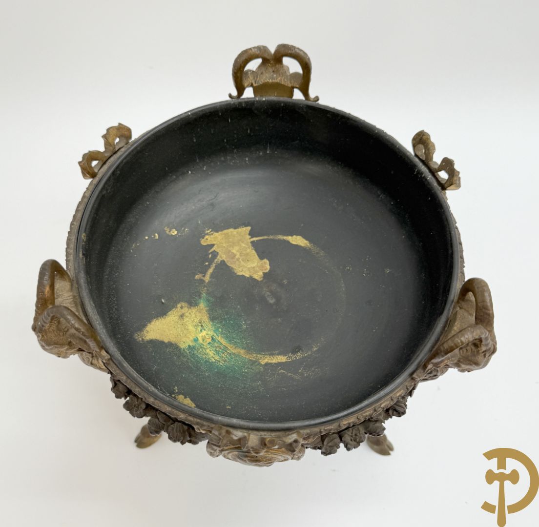 Bronzen coupe op 3 bokkepoten met ramskoppen  bezet en verbonden door guirlandes met medaillon