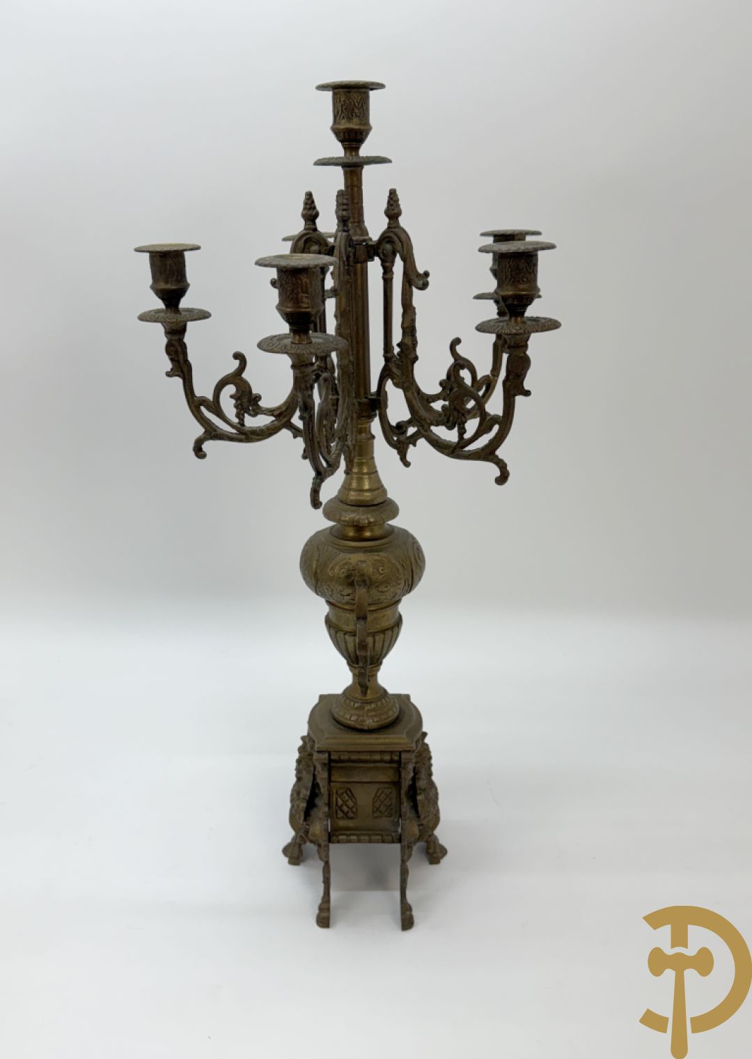 Driedelige koperen garnituur, klok geflankeerd door paar vijfarmige kandelaars