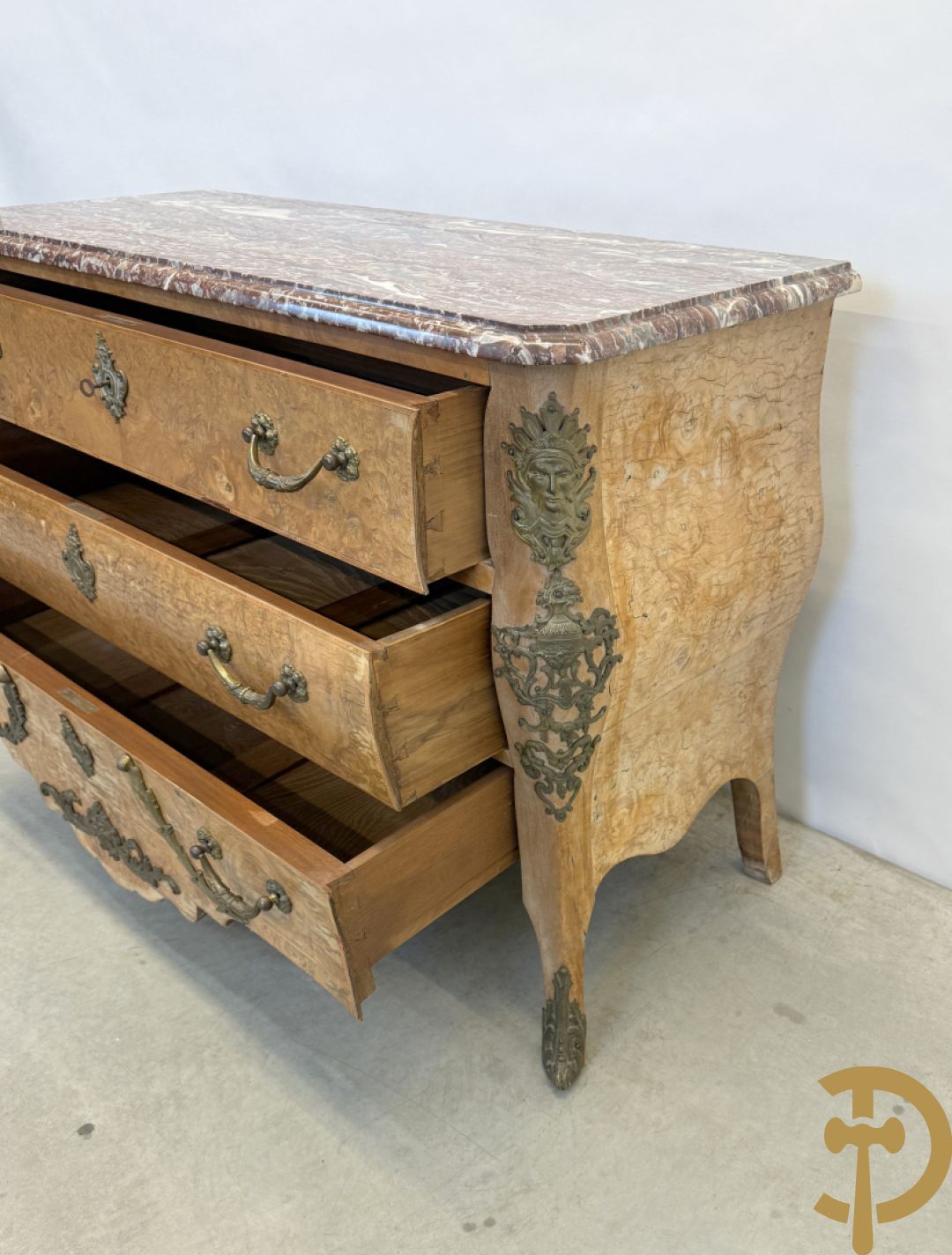 Wortelnotehouten drieladencommode met bronsbeslag van mazarinkoppen en accanthusranken, bovenaan met rood geaderd marmeren blad