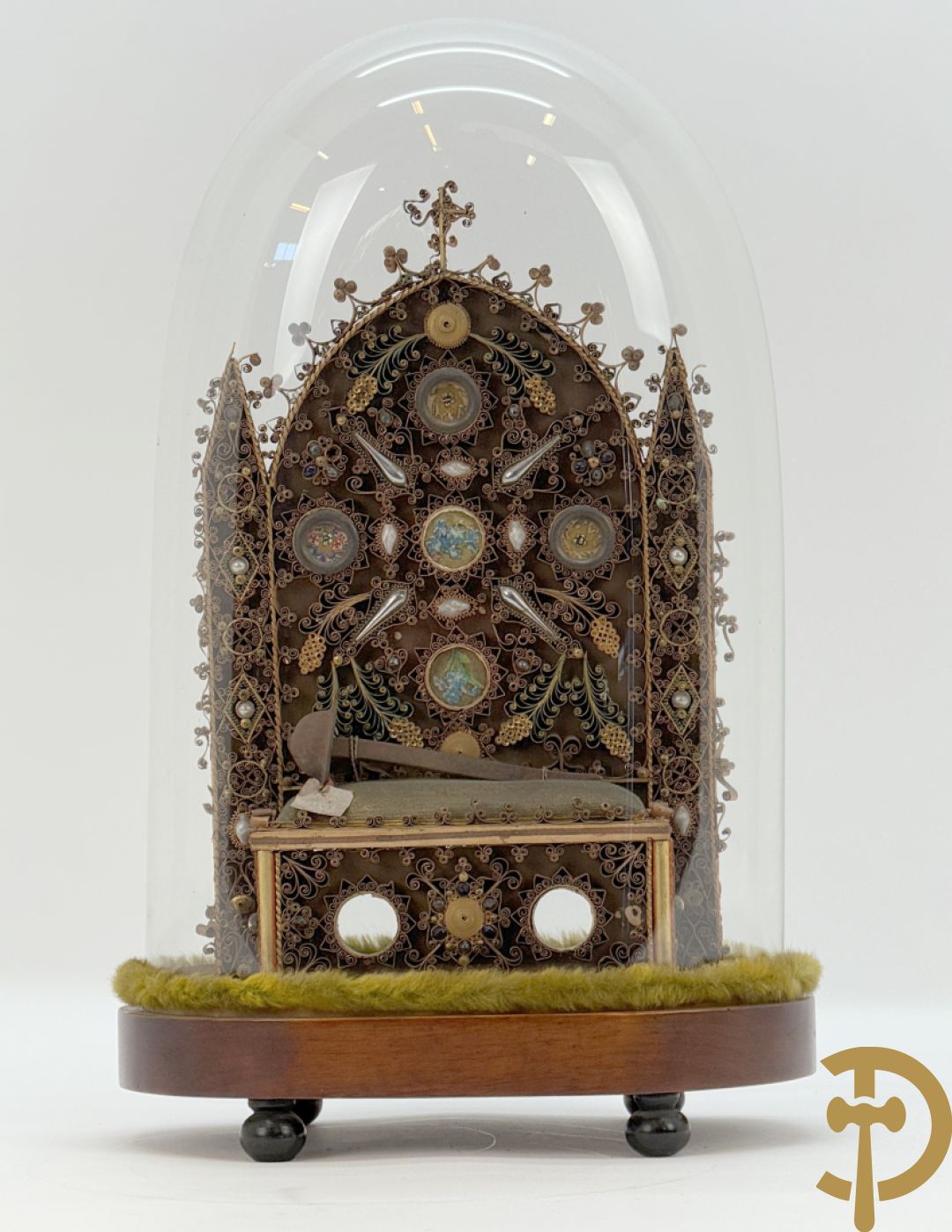 Relikwiehouder in de vorm van een altaar met Christusnagel en omgeven door papperollen - onder stolp